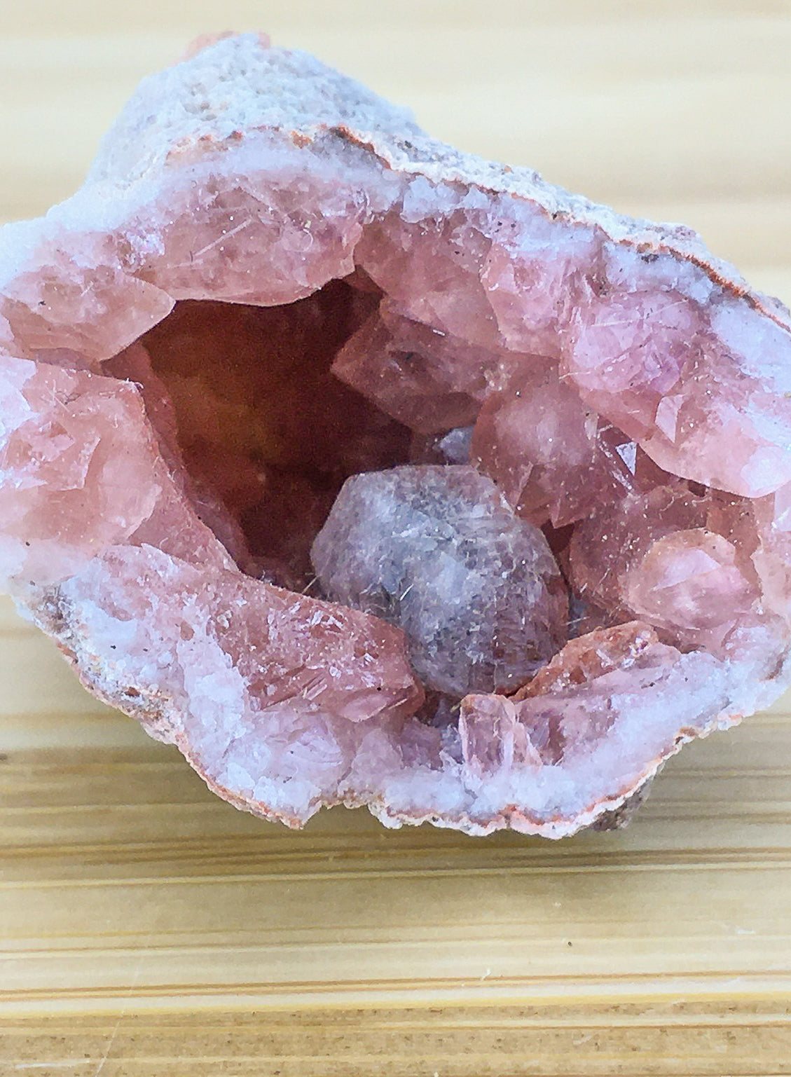 close up of pink amethyst crystals in a cracked geode
