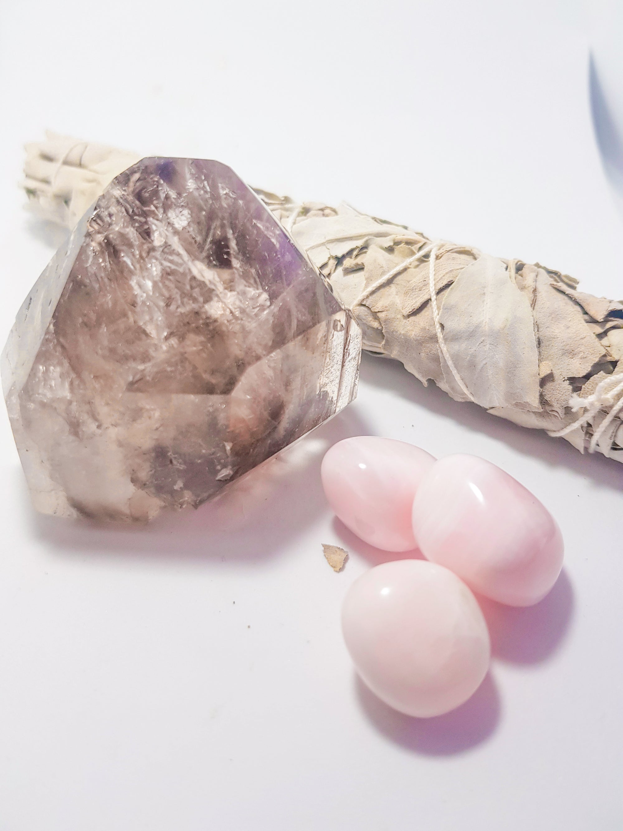 smoky quartz cut point with amethyst inclusion, 3 tumbled pieces of manganoalcite, 1 white sage smudge stick