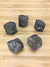 five twinned staurolite crystals on a light wood grain surface