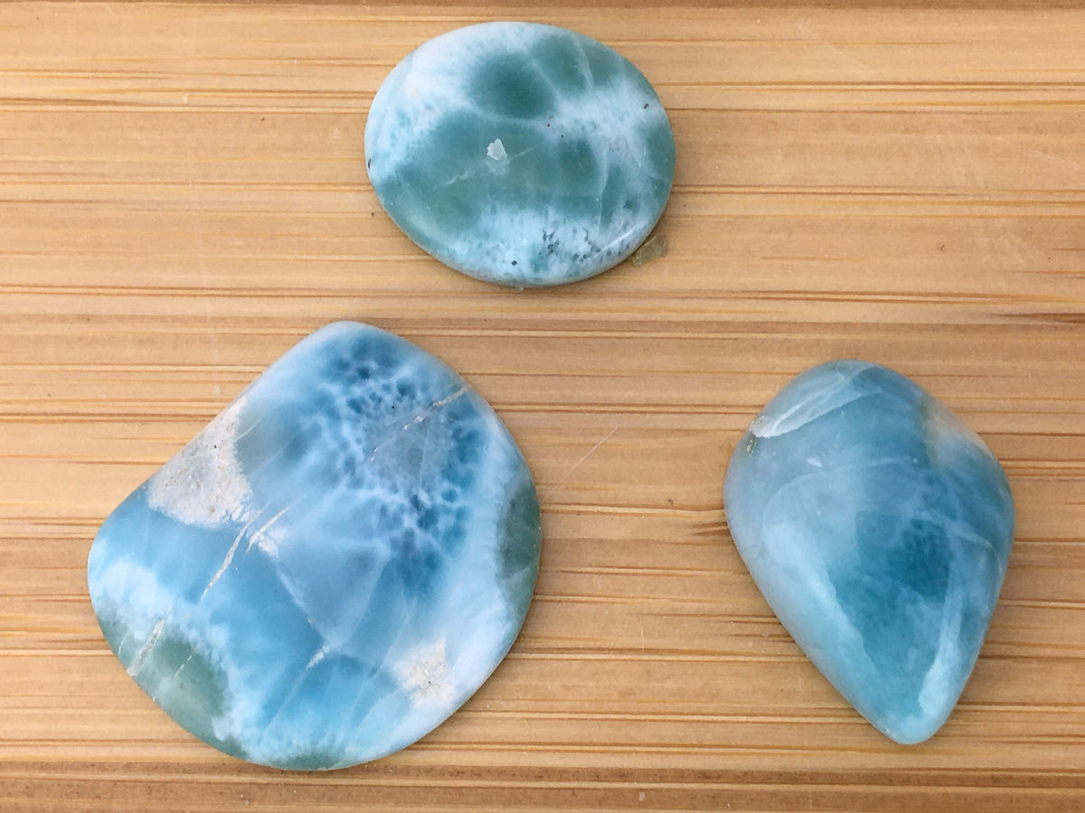 three Larimar cabochons. The pieces are a rich eatery blue.