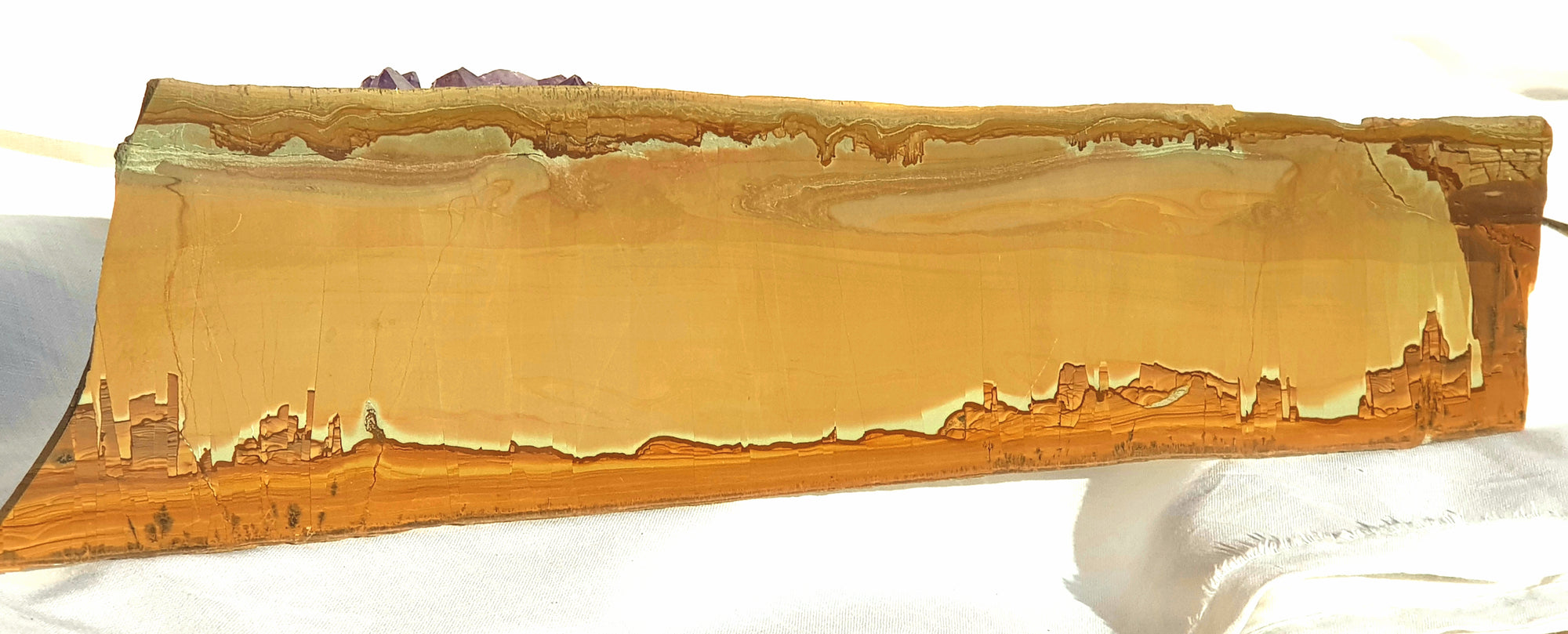 a polished slice of ruin marble. the piece is in shades of brown. the bottom of the image looks like a painted city, but is natural to the stone