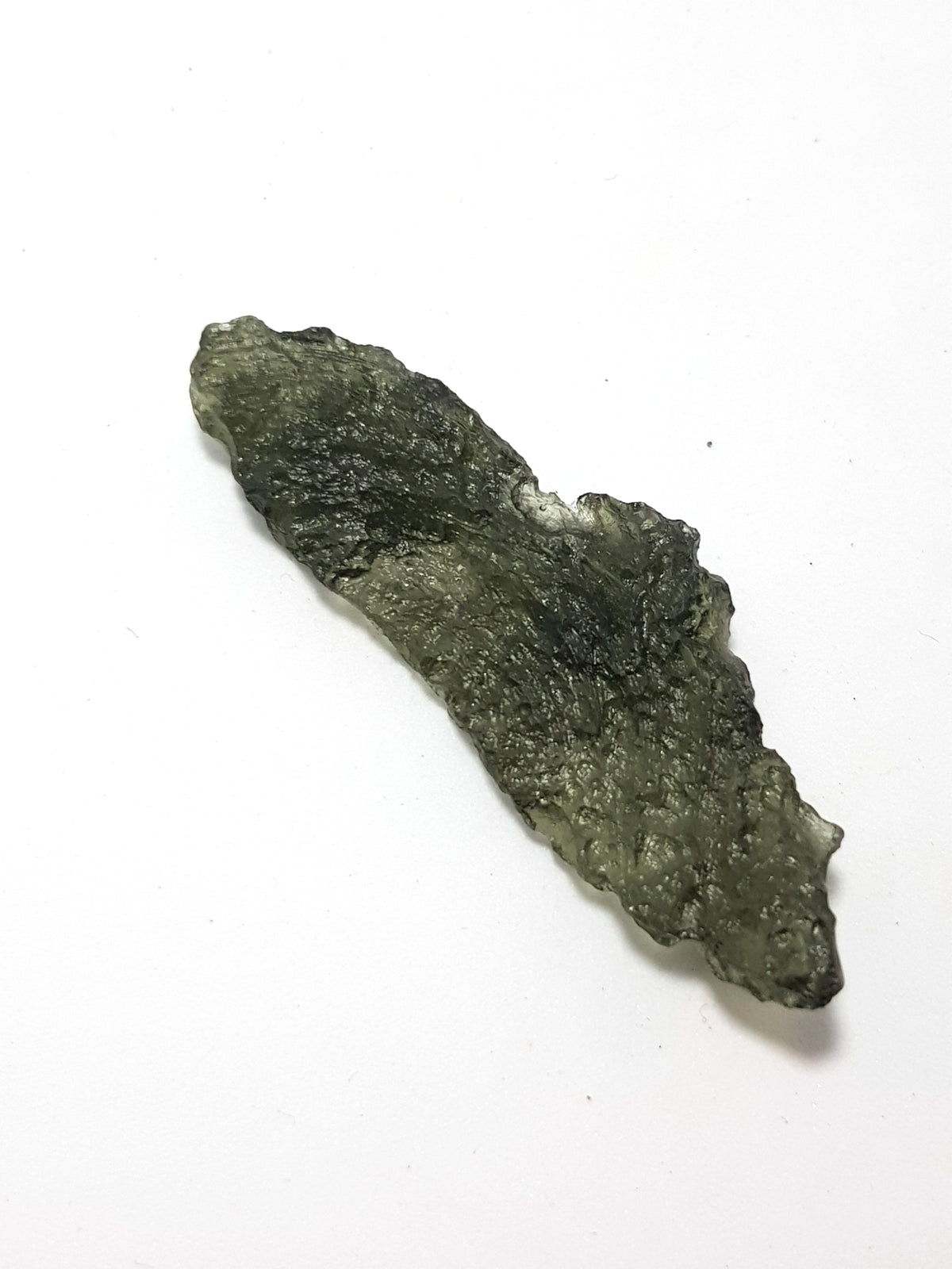 A sample of moldavite. It is green, slightly translucent and shows the famous wrinkled rind.