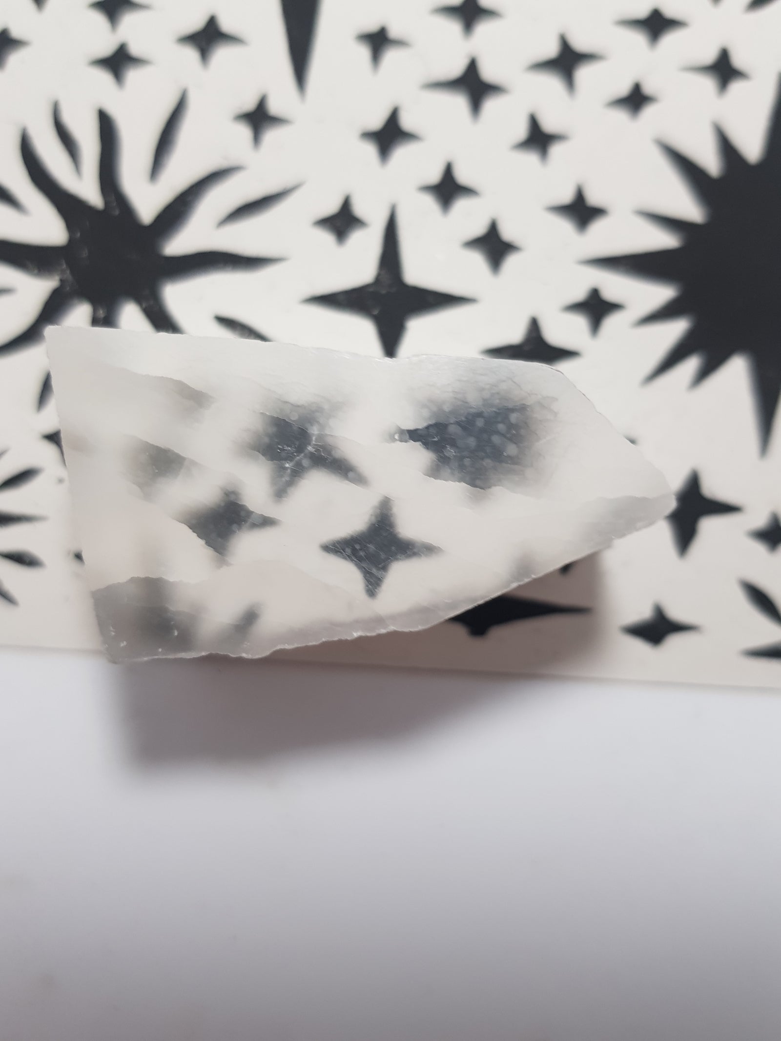 TV selenite on top of a star pattern display card. The image at the bottom is projected to the top of the surface.