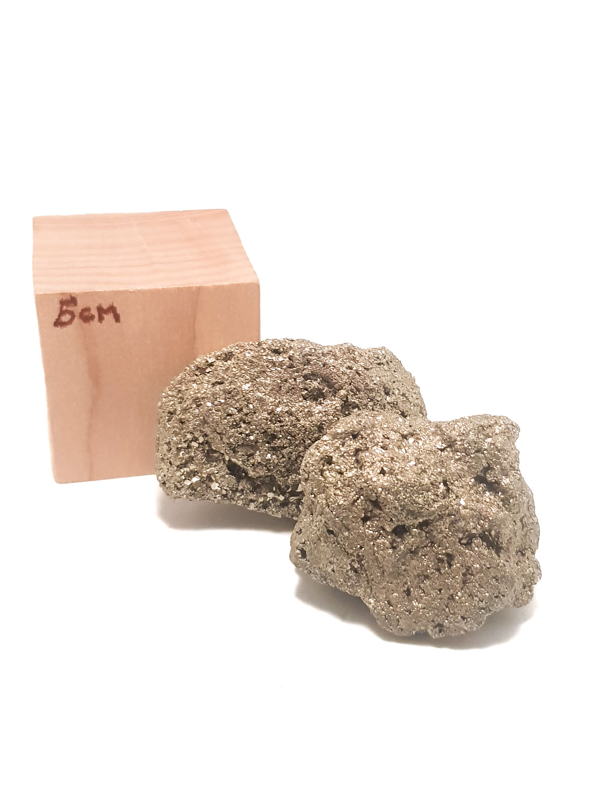 two iron pyrite &quot;cocos&quot;. They are placed next to a 5cm cube for scale