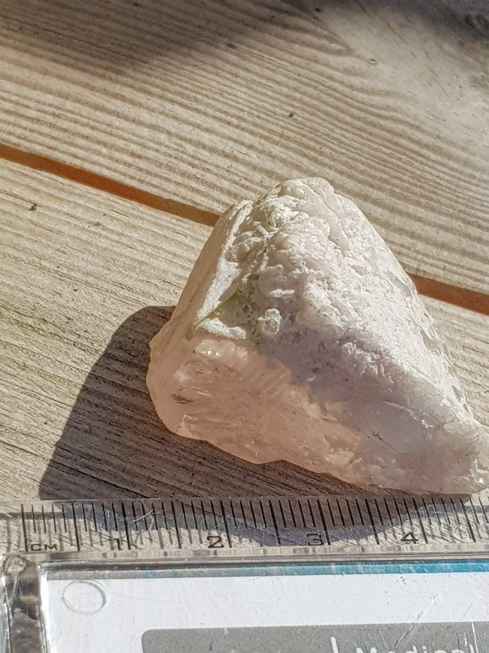 raw morganite crystal next to ruler. It is about 4cm along its longest axis