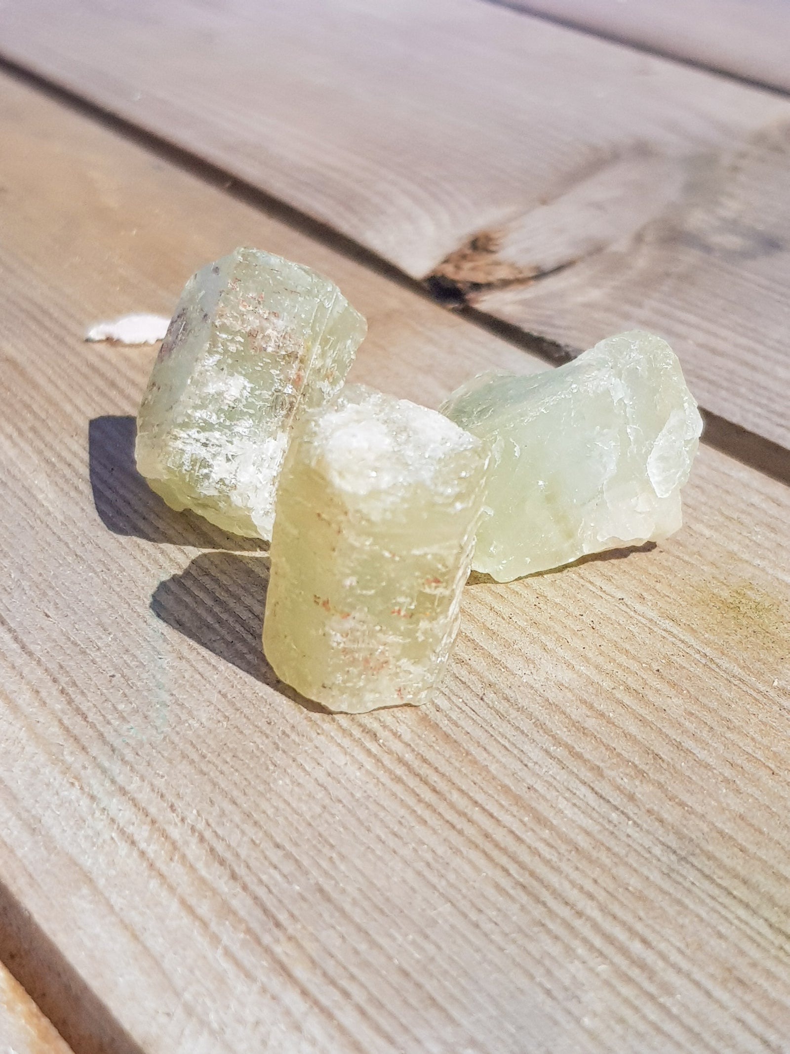 three beryl crystals. They have a hexagonal habit. They are a yellow/green