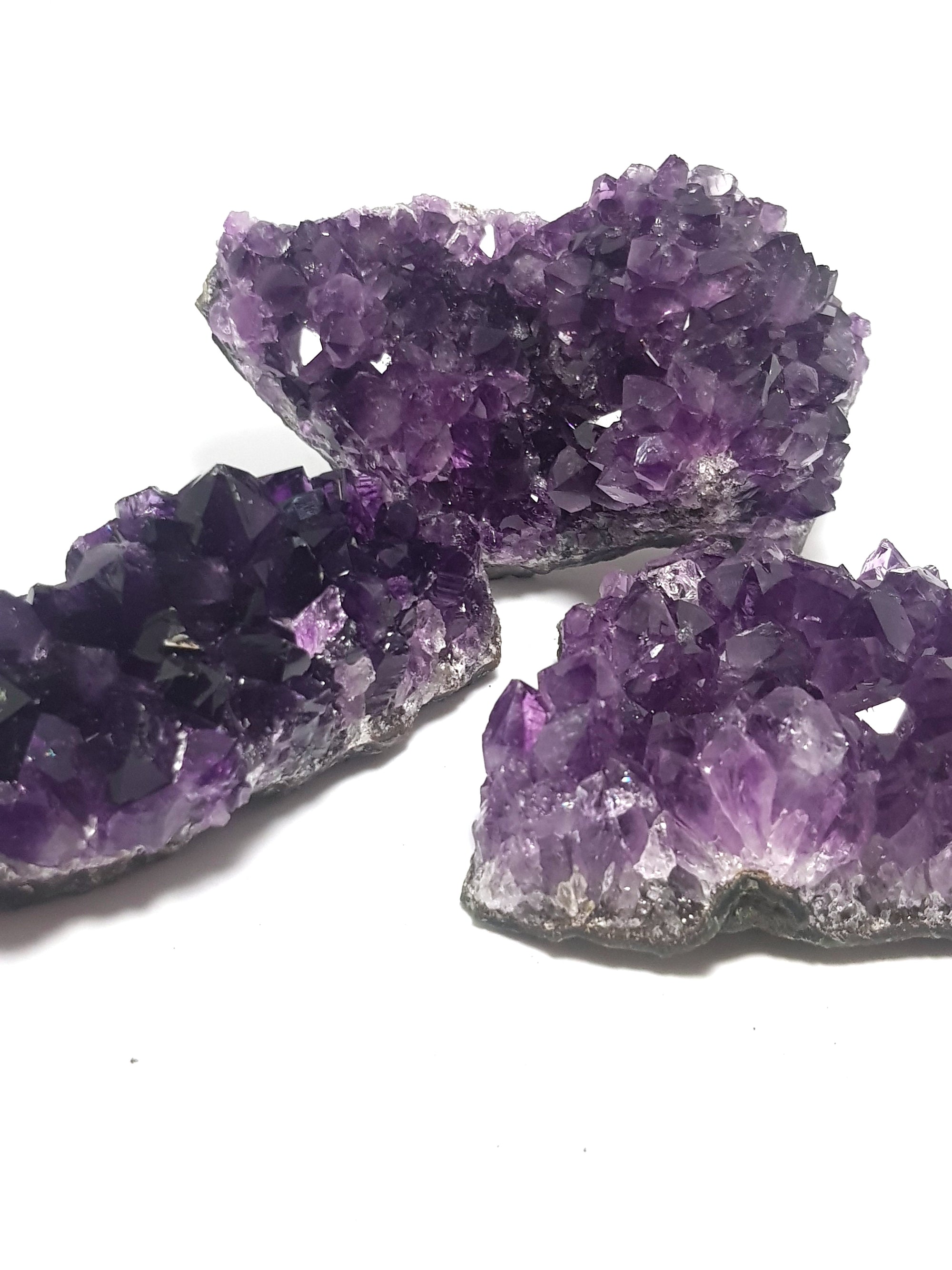 three pieces of a grade druzy amethyst from brazil. They are a deep purple colour and the crystals are well formed
