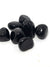 seven small apache tear tumble stones. They are black, opaque and highly reflective 