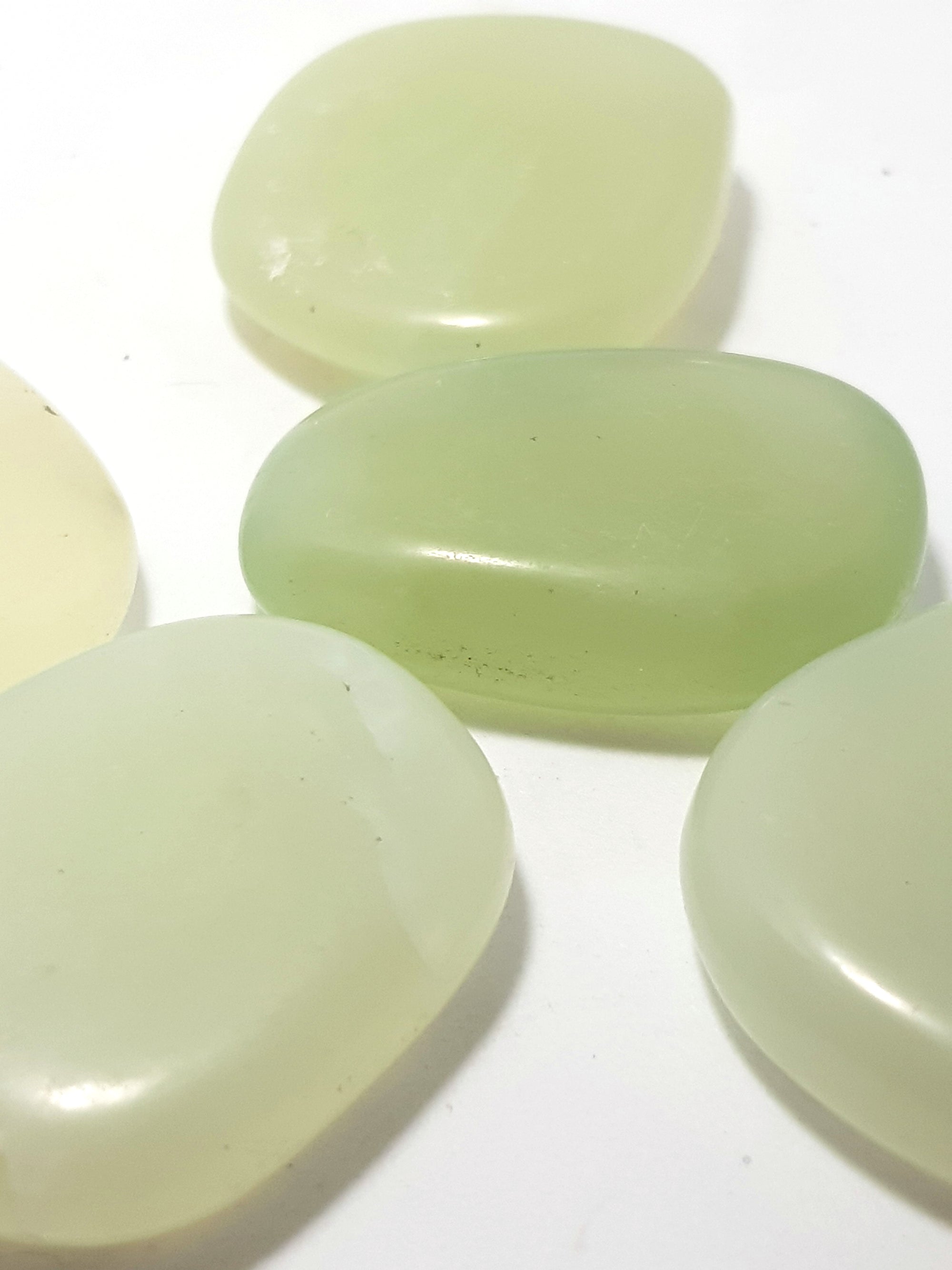 Bowenite palmstones. They are a soft green, slightly translucent and very smooth.