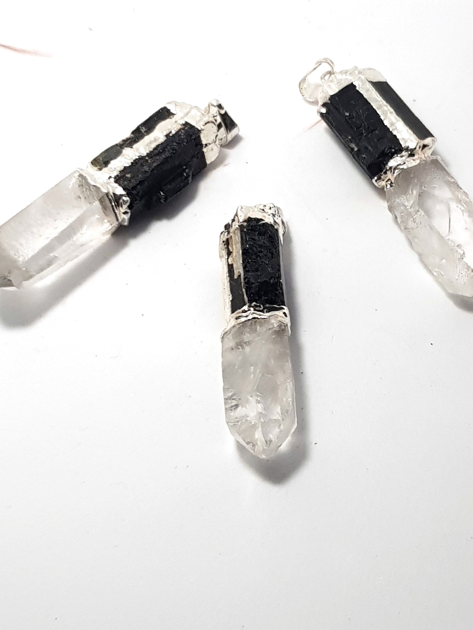 three natural crystal point pendants with  natural tourmaline and a metal bezel.