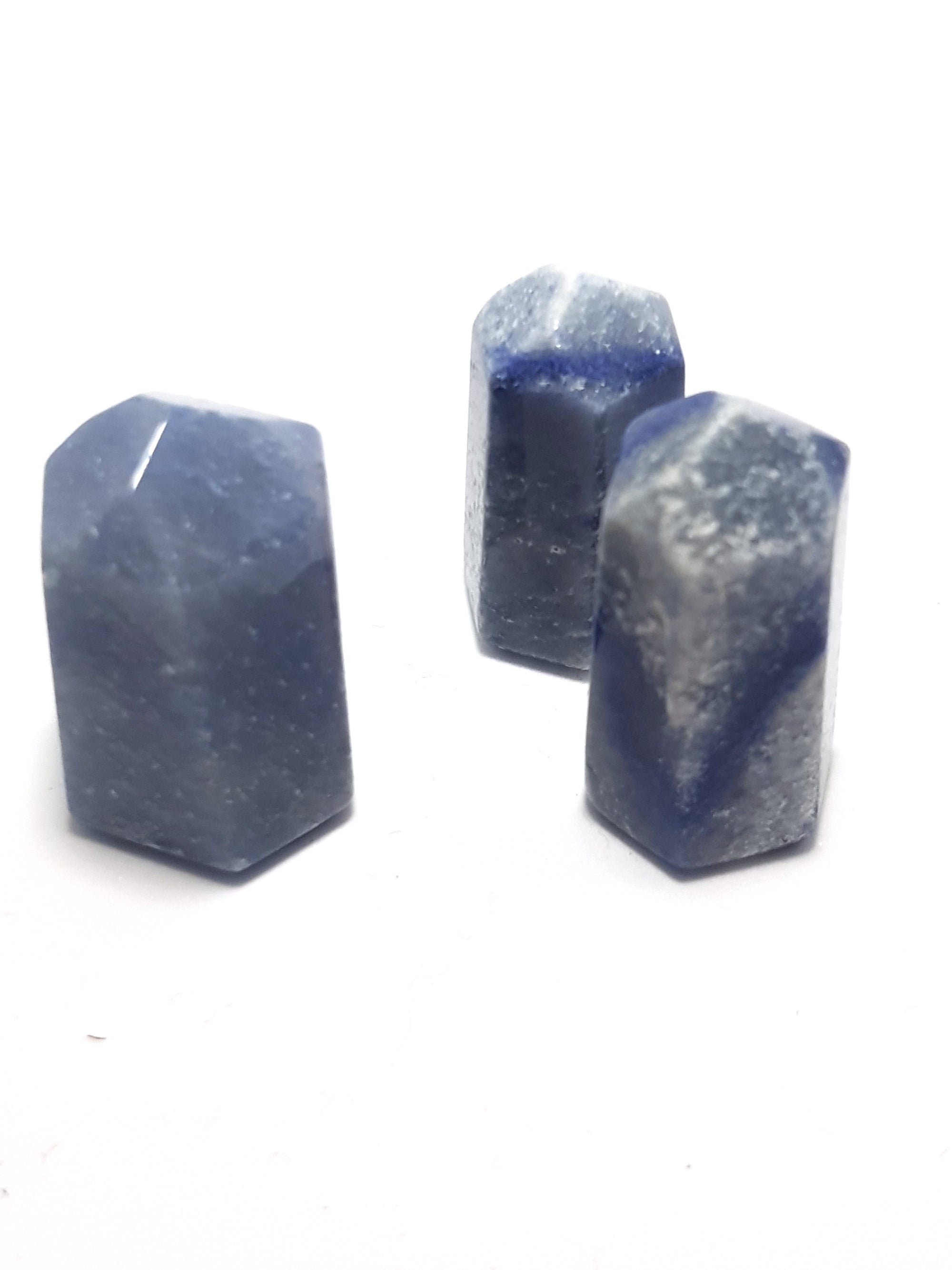three samples of dumorterite which have been cut into six sided obelix points. The samples are grey blue- with dark blue veining