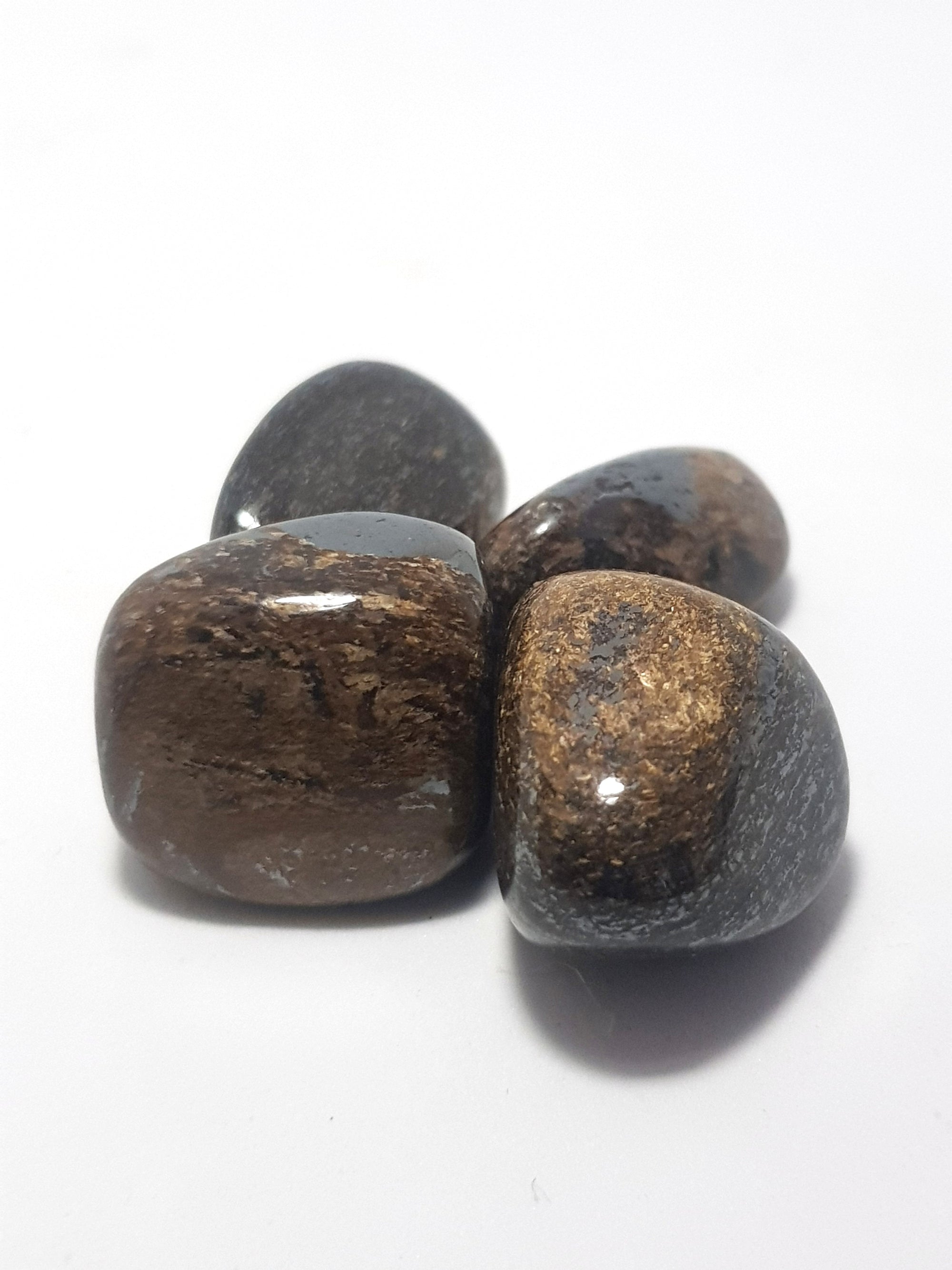 bronzite tumblestones. They are a brownish bronze colour, they appear to be finely laminated, with lines of a darker brown material. They show some chatoyancy.