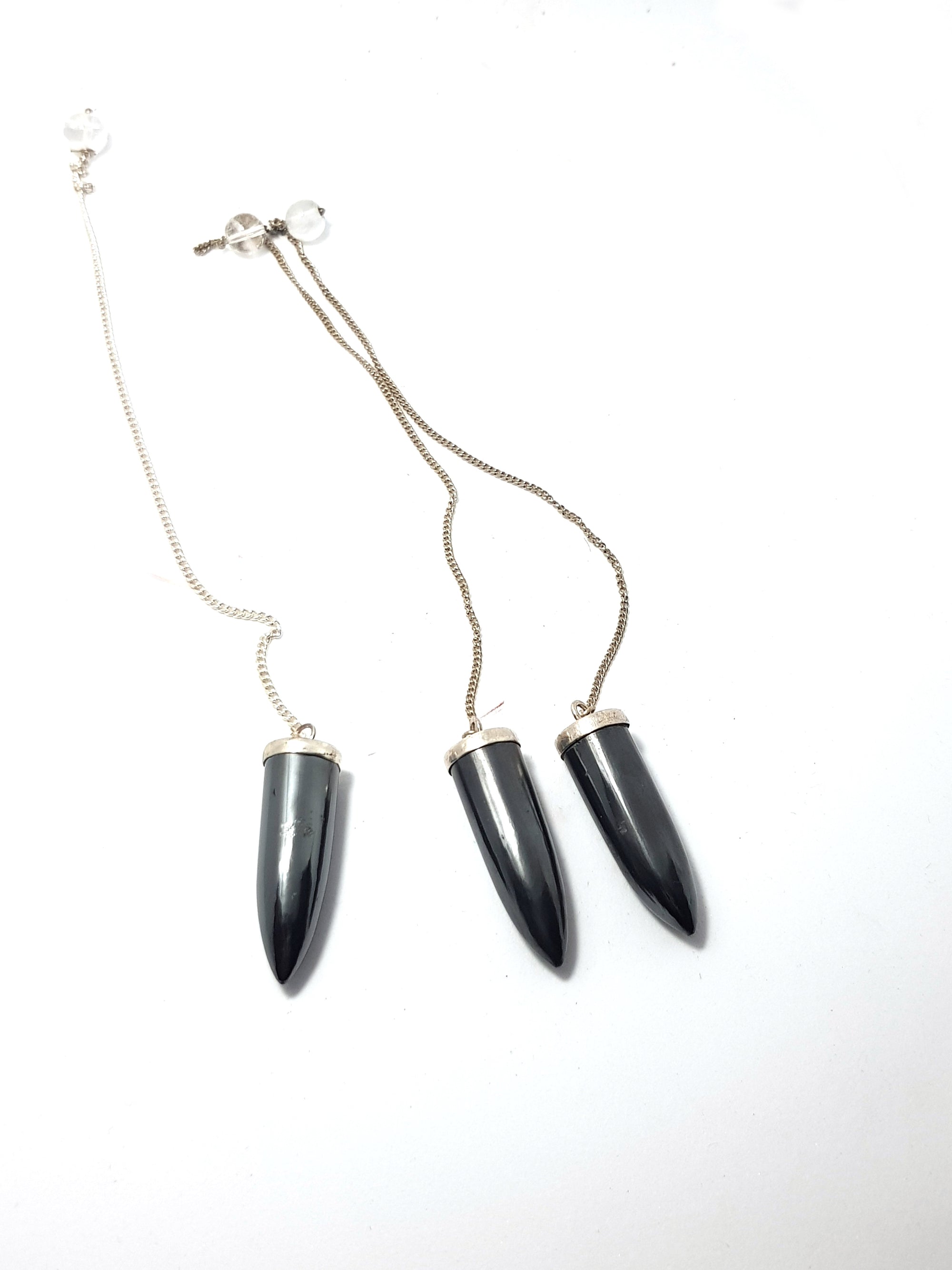 three hematite bullet shaped pendulums