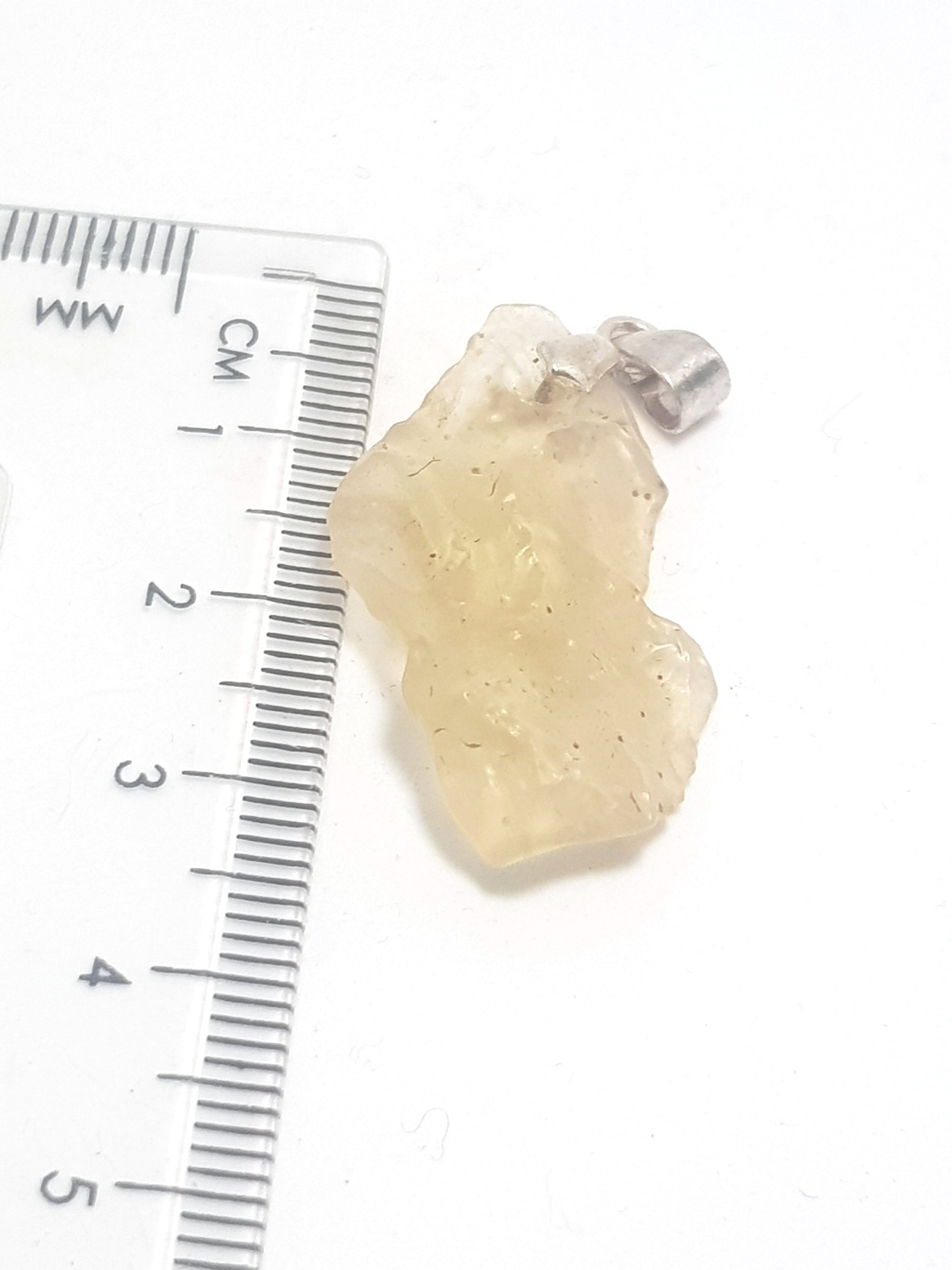 libyan desert glass pendant next to a ruler. it is 3 cm