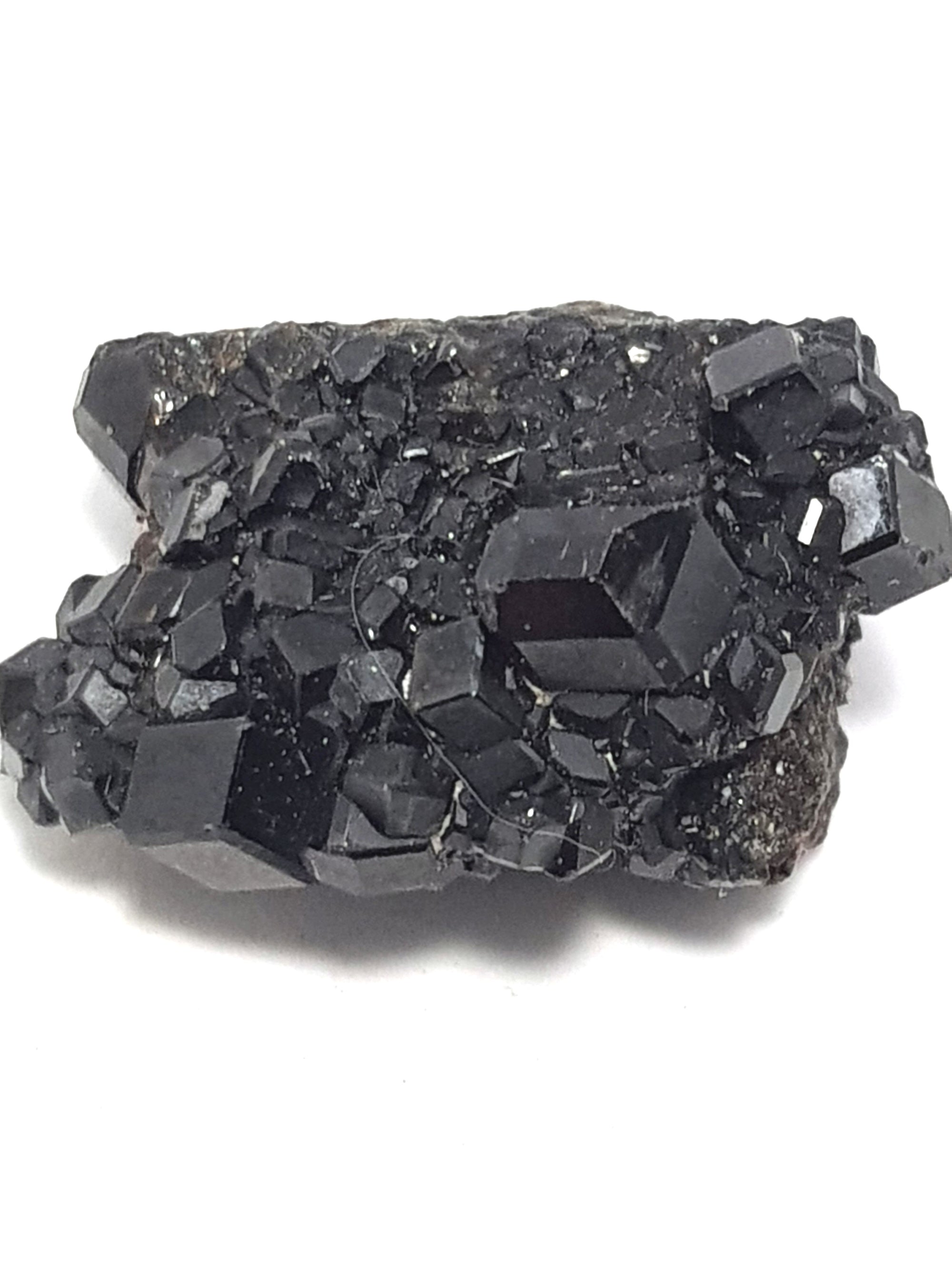 a cluster of black melanite crystals. The crystals are dodecahedrons. 