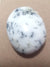 polished white opal pebble with black and grey dentriites
