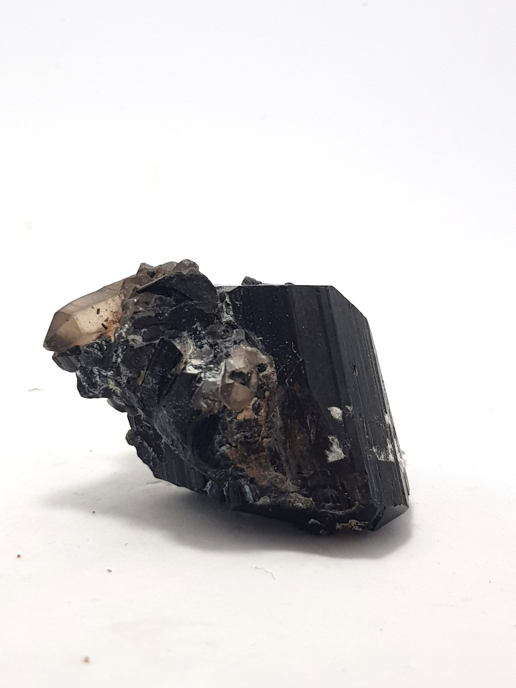 black tourmaline crystal. A well formed smoky quartz crystal is  on the top left