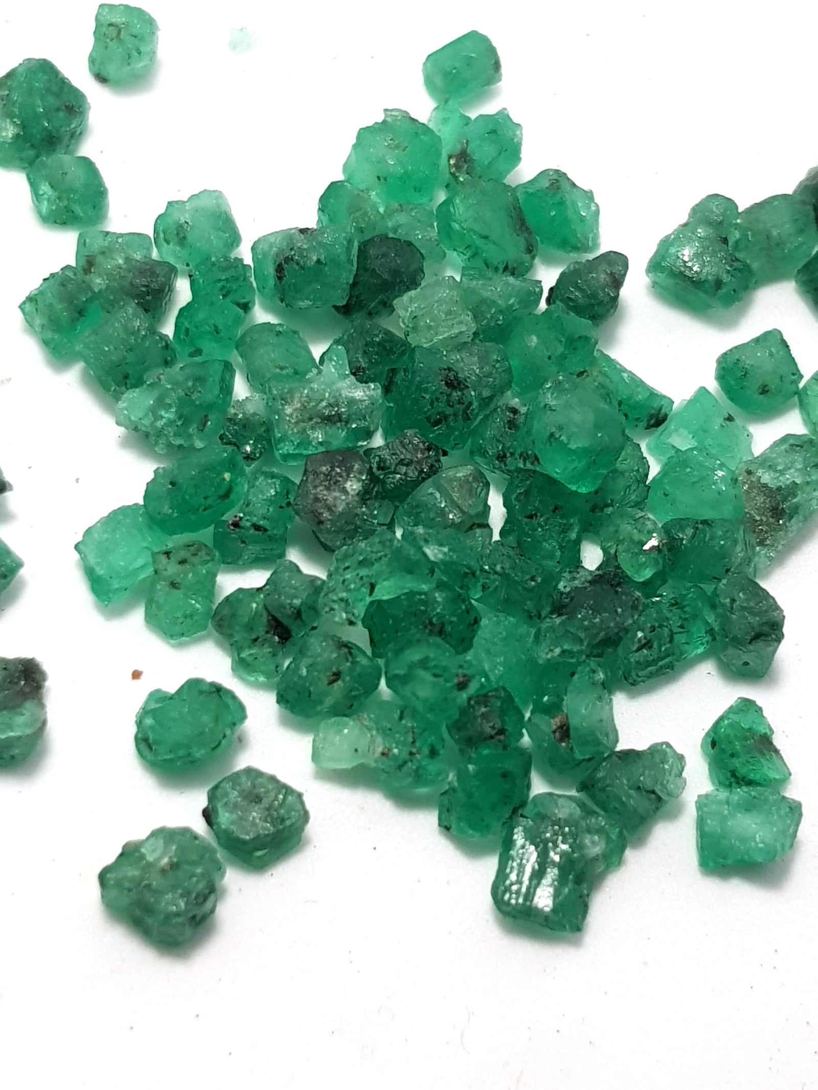 raw emeralds. very green and translucent. The pieces are small and regularly shaped.