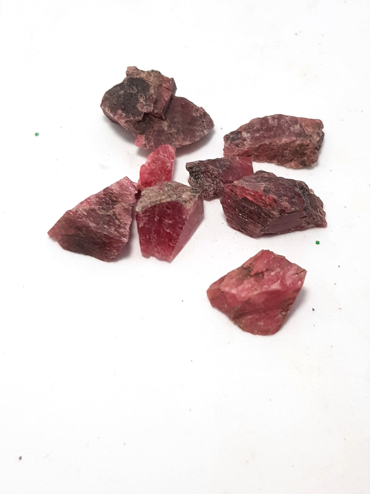 raw chips of rhodonite. They are a very dark pink.