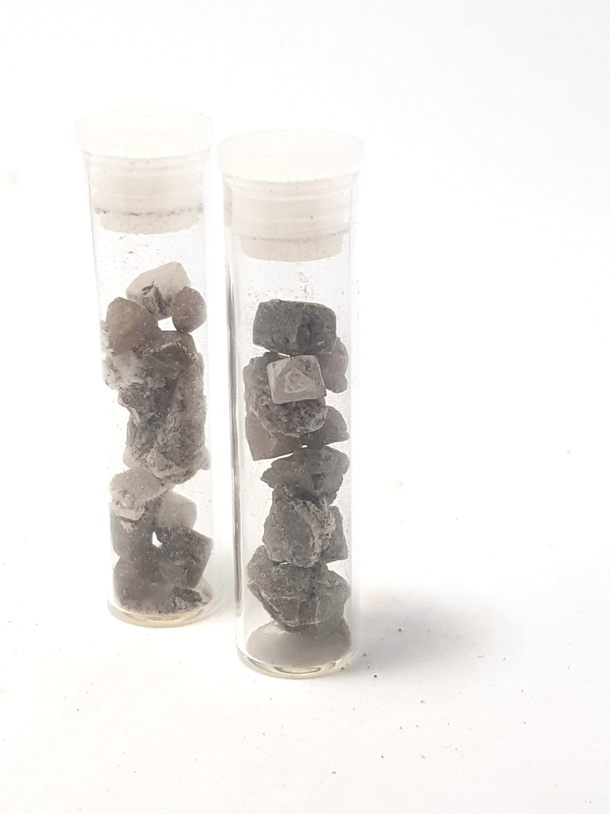 2 clear vials filled with grey struuvite crystals