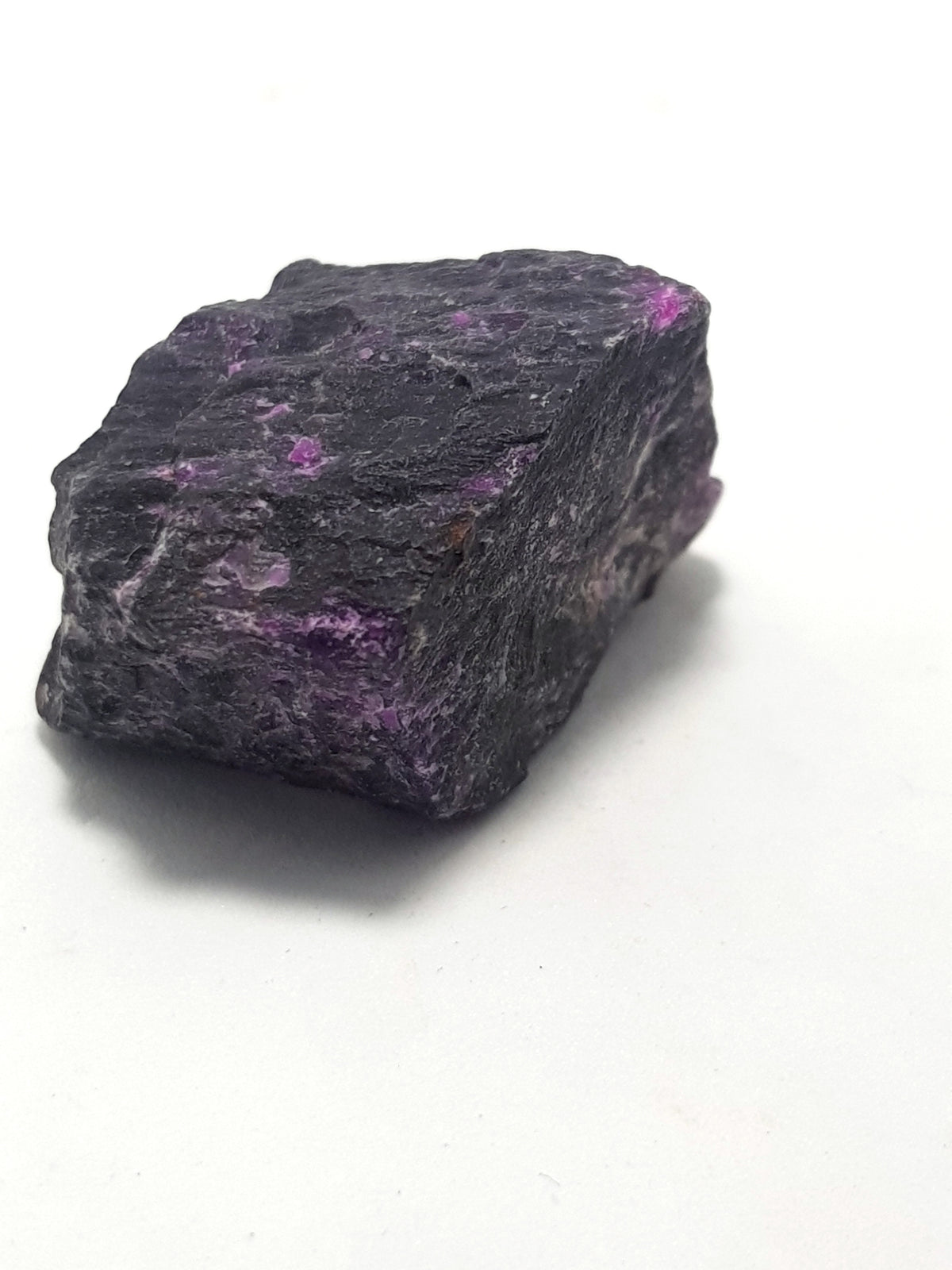 raw sugilite. This rough sample contains flecks and clusters of light purple sugilite in a black matrix